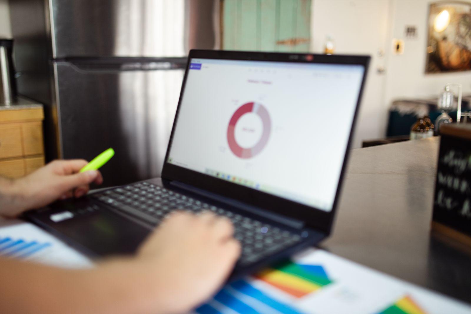 Hands working with analytics on a laptop